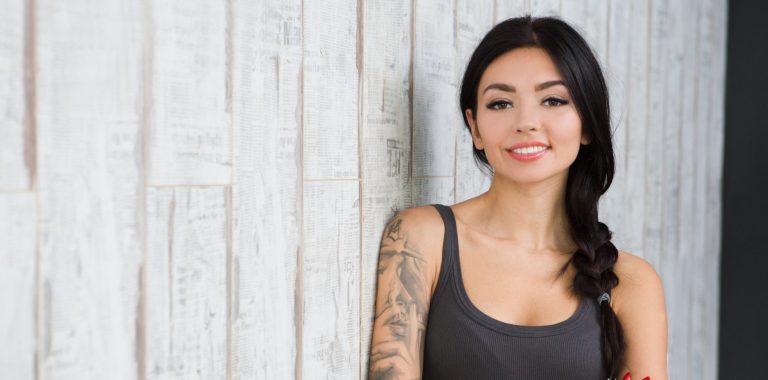 young hopeful ambiguous woman with tattoos